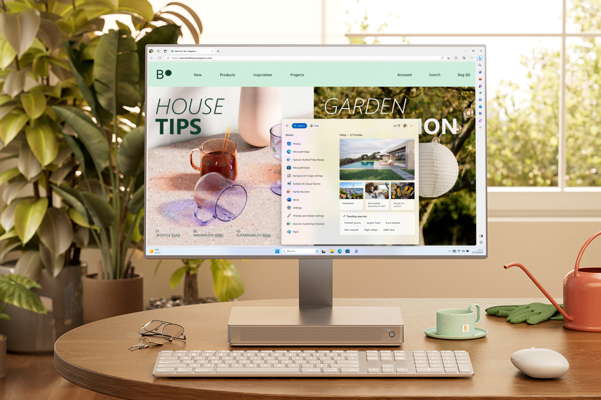 Leżący na biurku komputer PCSpecialist z systemem Windows i widocznym menu Start