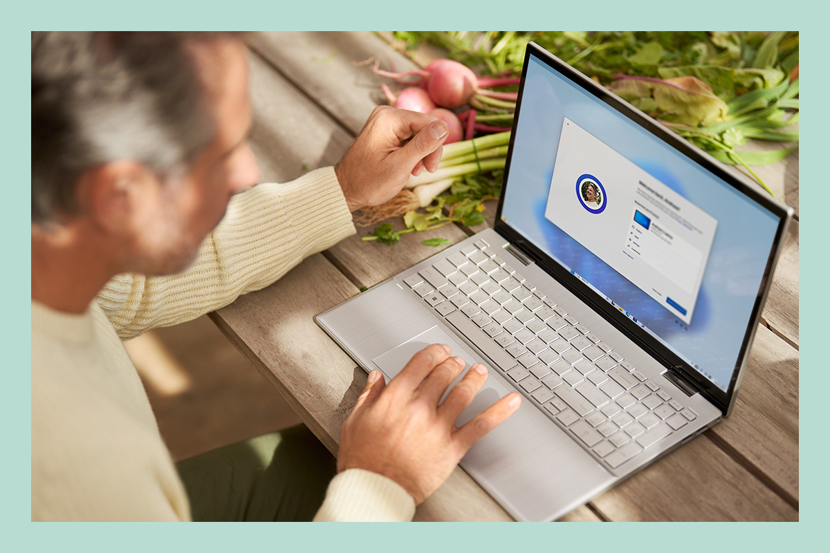 Mężczyzna używa laptopa z systemem Windows 11 do zarządzania plikami, aplikacjami i preferencjami.